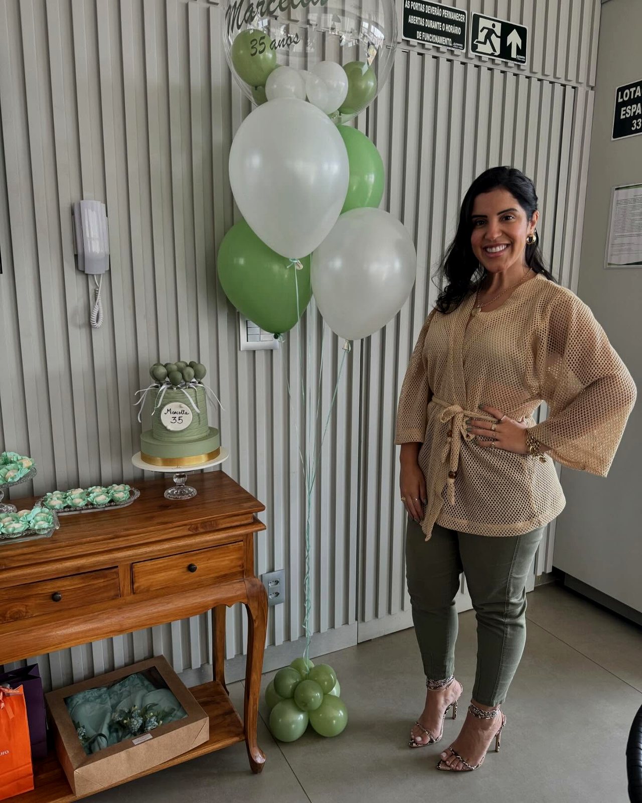 Decoração de evento com arranjo de balões verdes e brancos montado no local